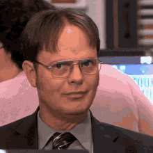 GIF da série The Office: personagem faz sinal de silêncio com o dedo nos lábios