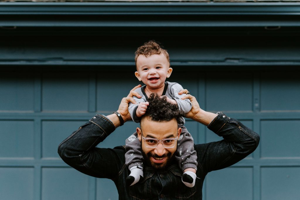 Foto de pai com o filho nos ombros representando o feriado de dia dos pais