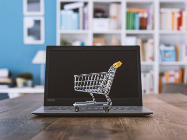 E-commerce 2023 representado por uma imagem com um carrinho de compras em cima de um notebook.